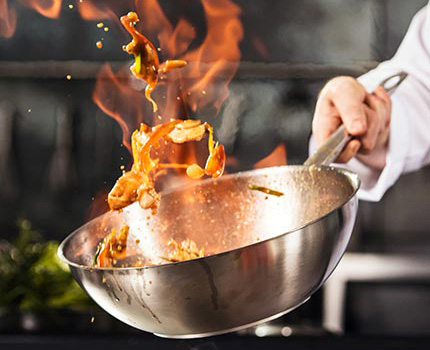 Chef tossing food in a pan