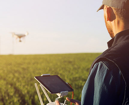 farmer operates drone over field