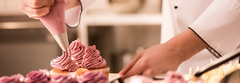 baker decorates cupcakes