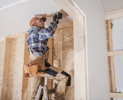 Builder putting up drywall