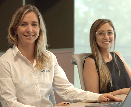 three workers in hard hats and safety gear inspect an item