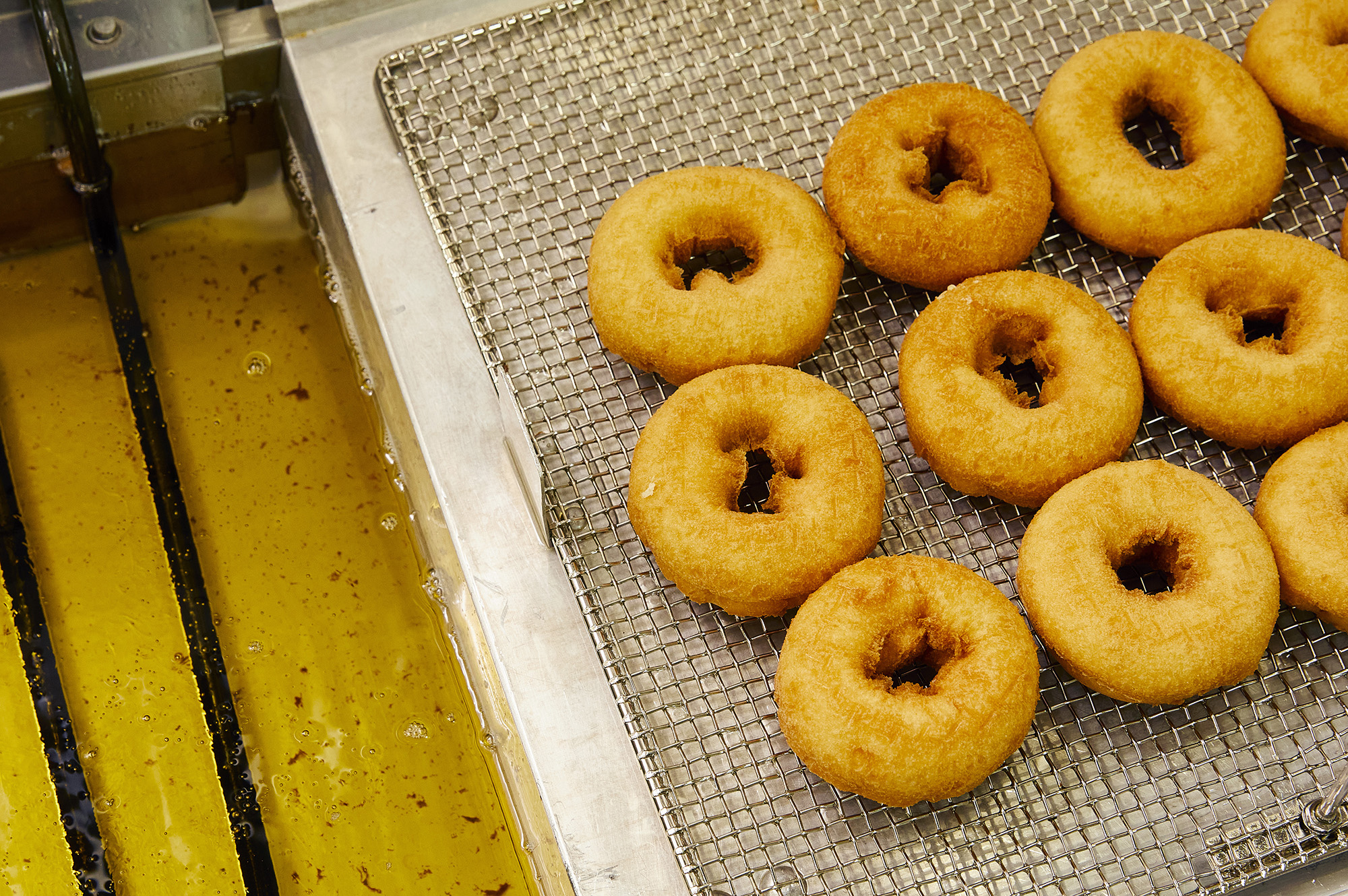 A tray of golden, unfrosted cake donuts.