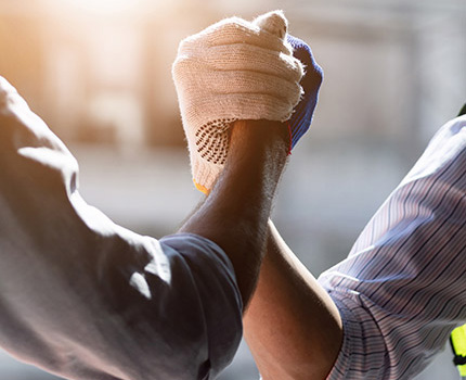 close up of two works shaking hands