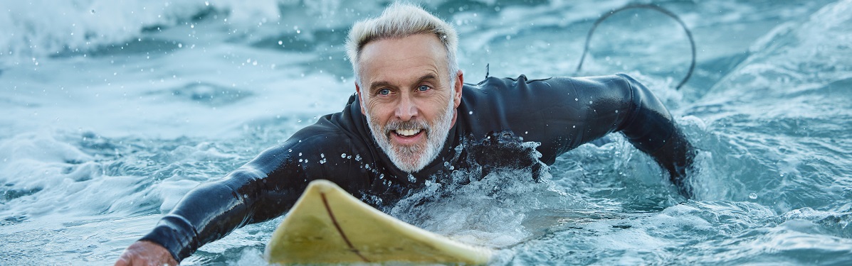 Older man paddling on surfboard