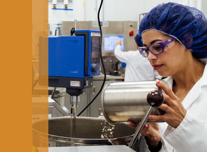 food lab worker pours ingredients into processor